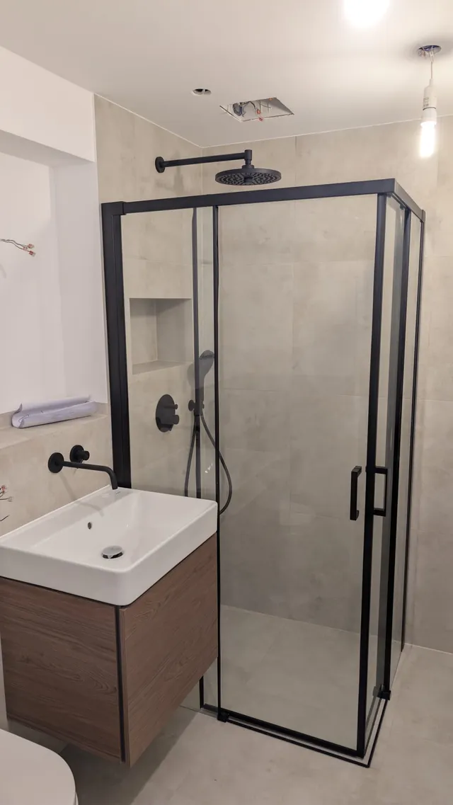 Fertig saniertes Badezimmer mit ebenerdiger Dusche, Glastrennwand und Holzwaschtisch
